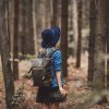 Young woman with binocular and backpack in a forest